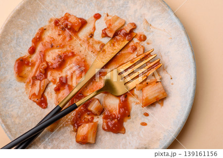 A dirty plate after a meal with leftover pasta and tomato sauce, cleaning. An empty dirty plate A dirty plate after a meal with leftover pasta and tomato sauce, cleaning. An empty dirty plate 139161156
