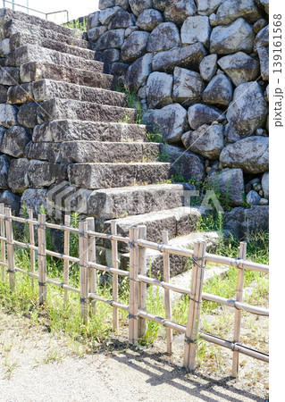 石垣に沿って伸びる古い石段と竹垣のある日本庭園風の風景 石垣に沿って伸びる古い石段と竹垣のある日本庭園風の風景 139161568