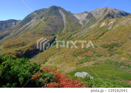 秋の装いに包まれた高山帯の稜線と連峰・色づく山肌と青空の山岳景観 秋の装いに包まれた高山帯の稜線と連峰・色づく山肌と青空の山岳景観 139162041