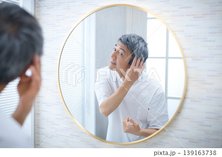 鏡を見て白髪を気にする60代の男性 鏡を見て白髪を気にする60代の男性 139163738