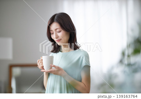 リラックスしてコーヒーを飲むミドル女性 139163764