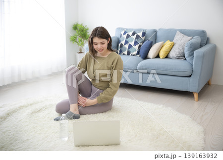 自宅でオンラインヨガを受ける若い女性 自宅でオンラインヨガを受ける若い女性 139163932