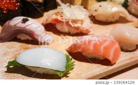 close up of six pieces of Japanese raw fish sashimi sushi displayed on a wooden board including salmon, squid, spring onion salmon, flounder, scallop, hamachi with copy space close up of six pieces of Japanese raw fish sashimi sushi displayed on a wooden board including salmon, squid, spring onion salmon, flounder, scallop, hamachi with copy space 139164120