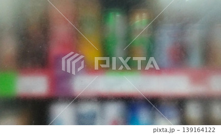 The store shelves appear blurry through the frosted glass backdrop. The store shelves appear blurry through the frosted glass backdrop. 139164122