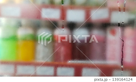 The store shelves appear blurry through the frosted glass backdrop. 139164124