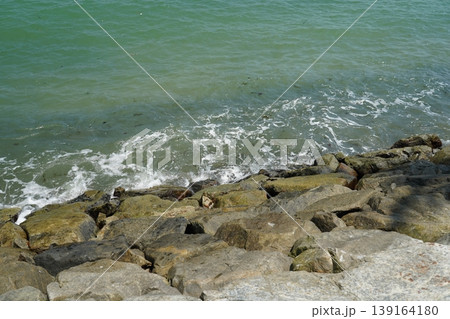 Waves Crashing on Rocks by the Sea Coast 139164180