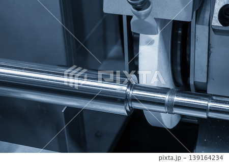 High-precision cylindrical grinding machine finishing a metal shaft for a smooth surface in a smart factory. High-precision cylindrical grinding machine finishing a metal shaft for a smooth surface in a smart factory. 139164234