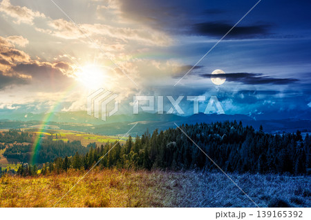 day meet night. mountain landscape on autumn equinox. sun and moon over green nature of carpathian mountains with fir forest. view of a scenery with rolling hills under epic sky. pasture near woods day meet night. mountain landscape on autumn equinox. sun and moon over green nature of carpathian mountains with fir forest. view of a scenery with rolling hills under epic sky. pasture near woods 139165392