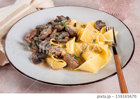Delicious pappardelle pasta with mushrooms and cream served on a white plate 139165670