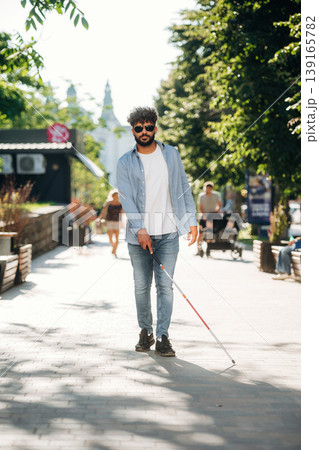 Practical use of cane stick. Blind man in sunglasses is in the city 139165782