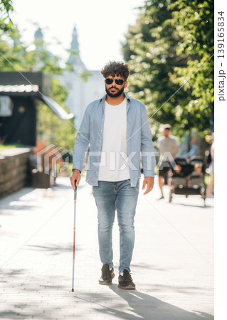 Practical use of cane stick. Blind man in sunglasses is in the city 139165834