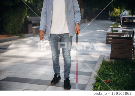 In casual clothes. A blind man with white cane is in the city 139165862