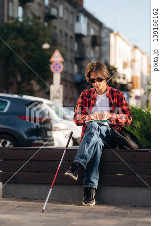 Blind young guy is in the town outdoors 139166162
