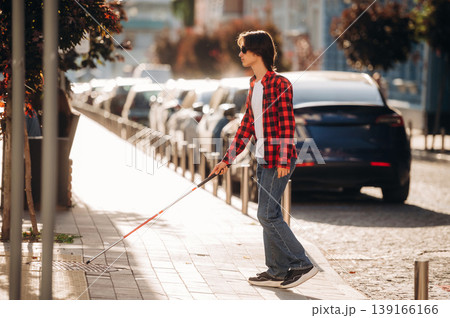 The practical use of white cane. Blind young guy is in the town outdoors 139166166
