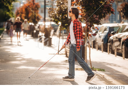 The practical use of white cane. Blind young guy is in the town outdoors 139166173