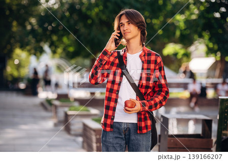 At sunny daytime. Young student is having a walk in the town 139166207