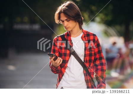 At sunny daytime. Young student is having a walk in the town 139166211