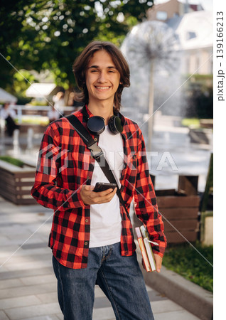 Wireless headphones on the neck. Young student is having a walk in the town 139166213