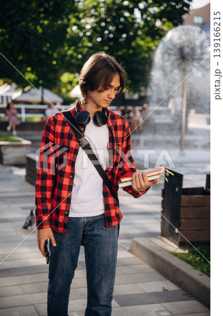 Wireless headphones on the neck. Young student is having a walk in the town Wireless headphones on the neck. Young student is having a walk in the town 139166215
