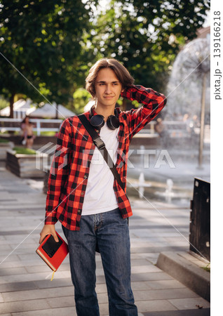 Wireless headphones on the neck. Young student is having a walk in the town 139166218