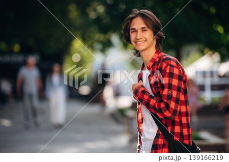 In red checkered shirt. Young student is having a walk in the town 139166219