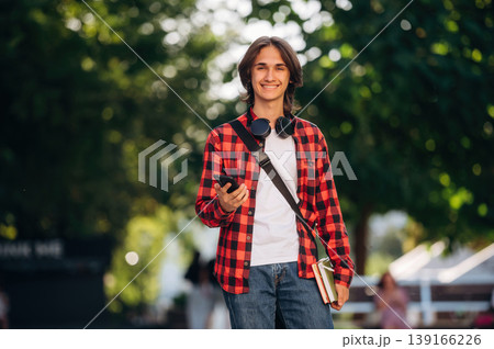 Feeling good, walking. Young student is outdoors at daytime Feeling good, walking. Young student is outdoors at daytime 139166226