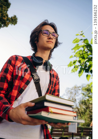 Many of the books in hands. Young student is having a walk in the town 139166232