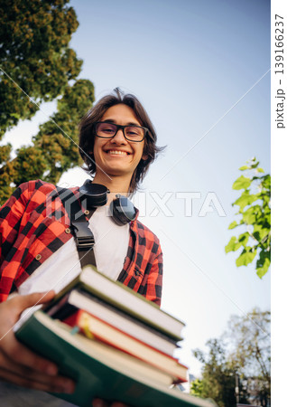 Many of the books in hands. Young student is having a walk in the town Many of the books in hands. Young student is having a walk in the town 139166237