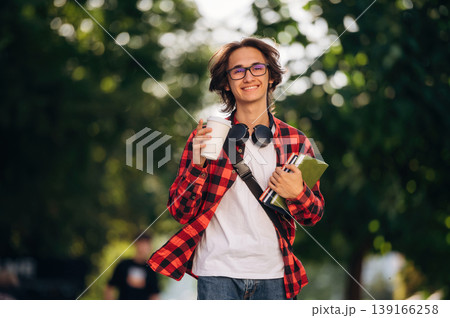 Smart, in glasses. Young student is having a walk in the town 139166258