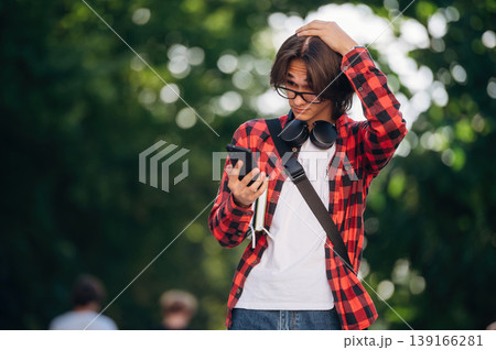 Having glasses on. Young student is having a walk in the town 139166281