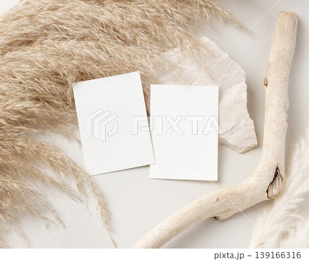 Blank cards set mockup on beige stone with driftwood and pampas grass top view, wedding stationery Blank cards set mockup on beige stone with driftwood and pampas grass top view, wedding stationery 139166316