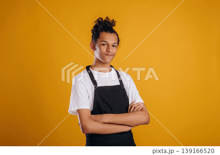 Barista is in apron. Young guy is against yellow background Barista is in apron. Young guy is against yellow background 139166520