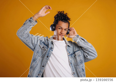 Music lover, in headphones. Young guy is against yellow background 139166556