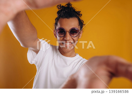 Selfie time, posing. Young guy is against yellow background Selfie time, posing. Young guy is against yellow background 139166586