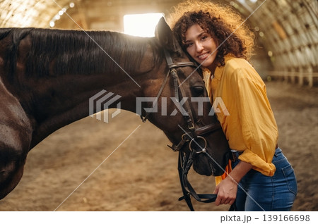 Love and care conception. Beautiful young woman is with horse in hangar 139166698