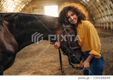 Love and care conception. Beautiful young woman is with horse in hangar 139166699