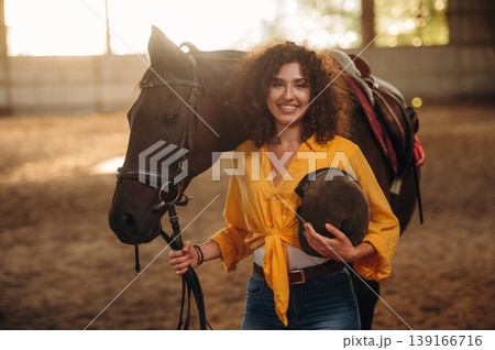 Standing and posing. Beautiful young woman is with horse in hangar Standing and posing. Beautiful young woman is with horse in hangar 139166716