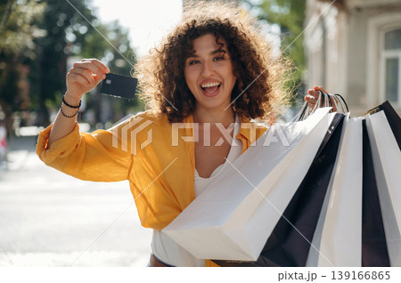 Ready to use the credit card. Happy woman is with shopping bags in town 139166865
