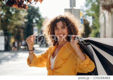 Credit card is in hand. Happy woman is with shopping bags in town 139166868