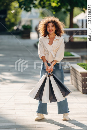 Gorgeous happy woman is with shopping bags in town Gorgeous happy woman is with shopping bags in town 139166886