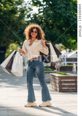 Weekend activities conception. Happy woman is with shopping bags in town Weekend activities conception. Happy woman is with shopping bags in town 139166904