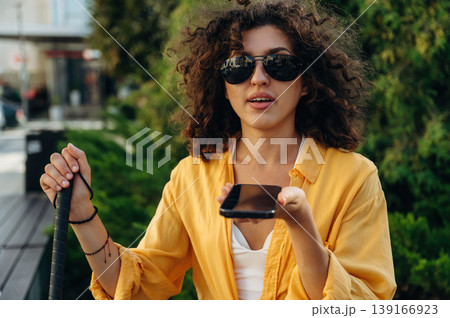 Talking by phone. A blind woman is in the modern city at daytime 139166923
