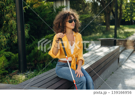 A blind woman is in the modern city at daytime A blind woman is in the modern city at daytime 139166956