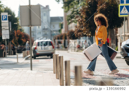 Crossing the road. Happy woman is with shopping bags in town 139166992