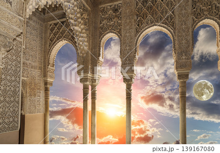 Arches in Islamic (Moorish) style (against the sunset with the super moon) in Alhambra, Granada, Spain Arches in Islamic (Moorish) style (against the sunset with the super moon) in Alhambra, Granada, Spain 139167080