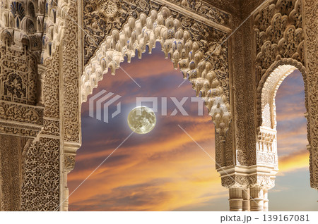 Arches in Islamic (Moorish) style (against the sunset with the super moon) in Alhambra, Granada, Spain  139167081