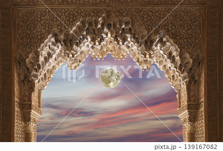 Arches in Islamic (Moorish) style (against the sunset with the super moon) in Alhambra, Granada, Spain  139167082