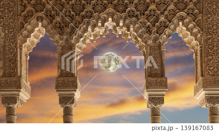 Arches in Islamic (Moorish) style (against the sunset with the super moon) in Alhambra, Granada, Spain  139167083