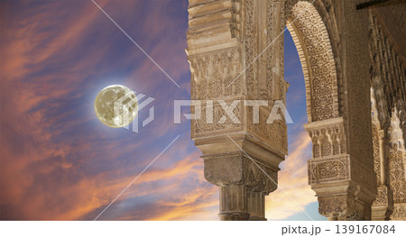 Arches in Islamic (Moorish) style (against the sunset with the super moon) in Alhambra, Granada, Spain  139167084