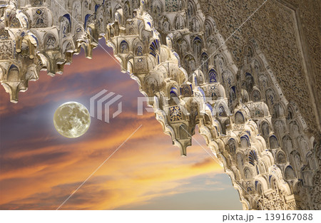 Arches in Islamic (Moorish) style (against the sunset with the super moon) in Alhambra, Granada, Spain  139167088